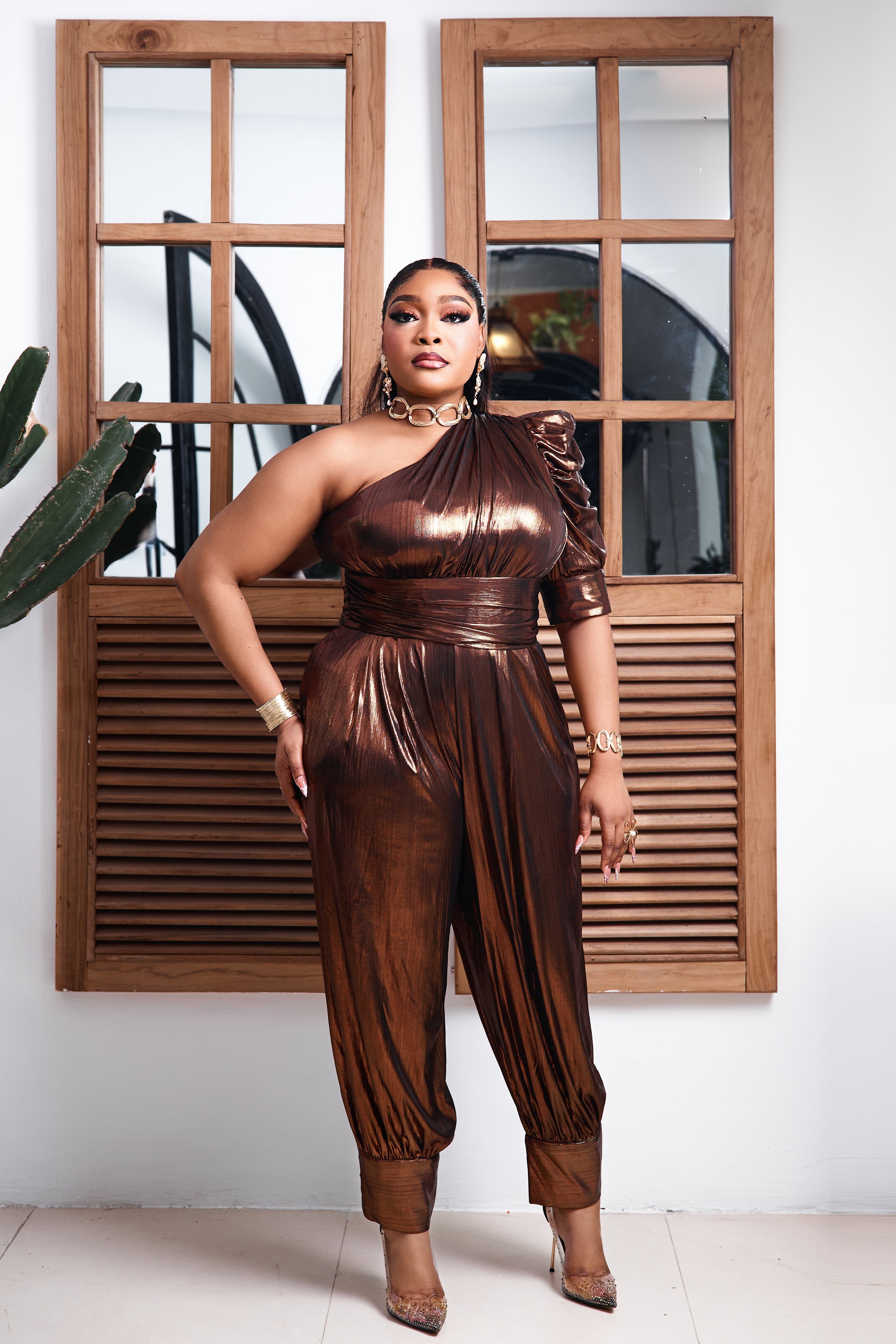 Bronze Goddess STERA FASHION jumpsuit in bronze fabric, showcasing a stylish, sleeveless design with a fitted waist and wide-leg pants.