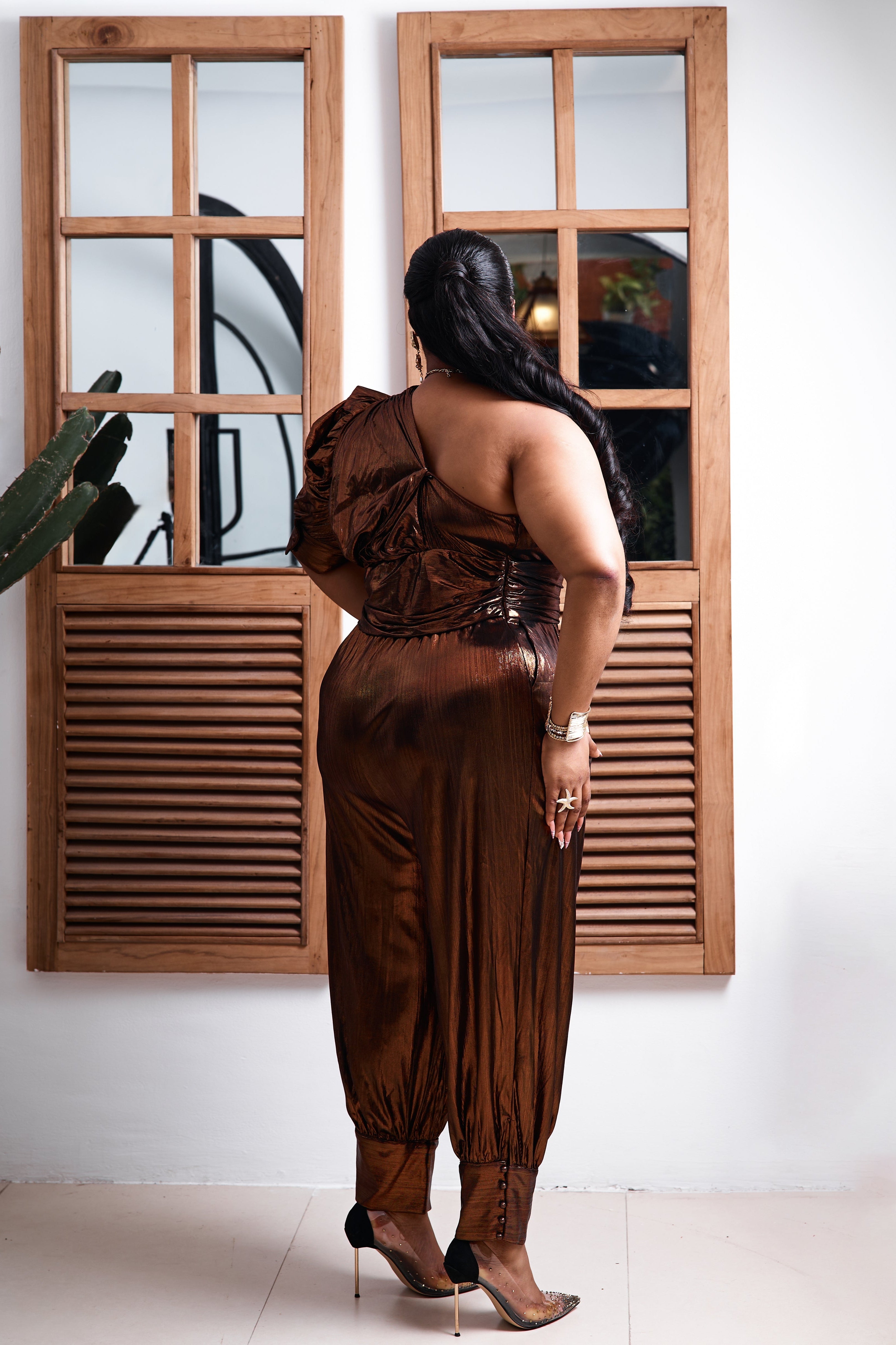Sterra Fashion Bronze Goddess jumpsuit in bronze fabric, featuring a stylish sleeveless design, wide legs, and a fitted waist.