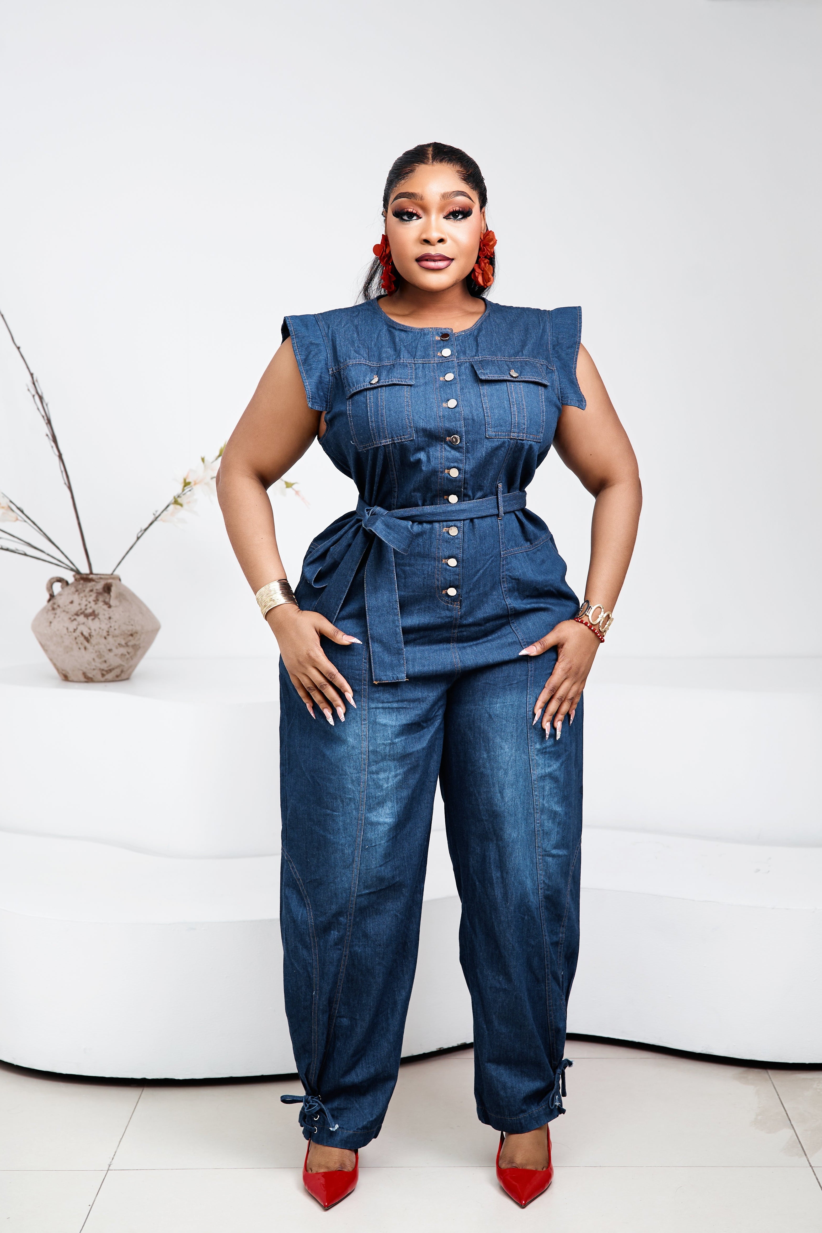Sterra Fashion Stacia denim jumpsuit displayed on a hanger, featuring a fitted bodice and wide-leg pants.