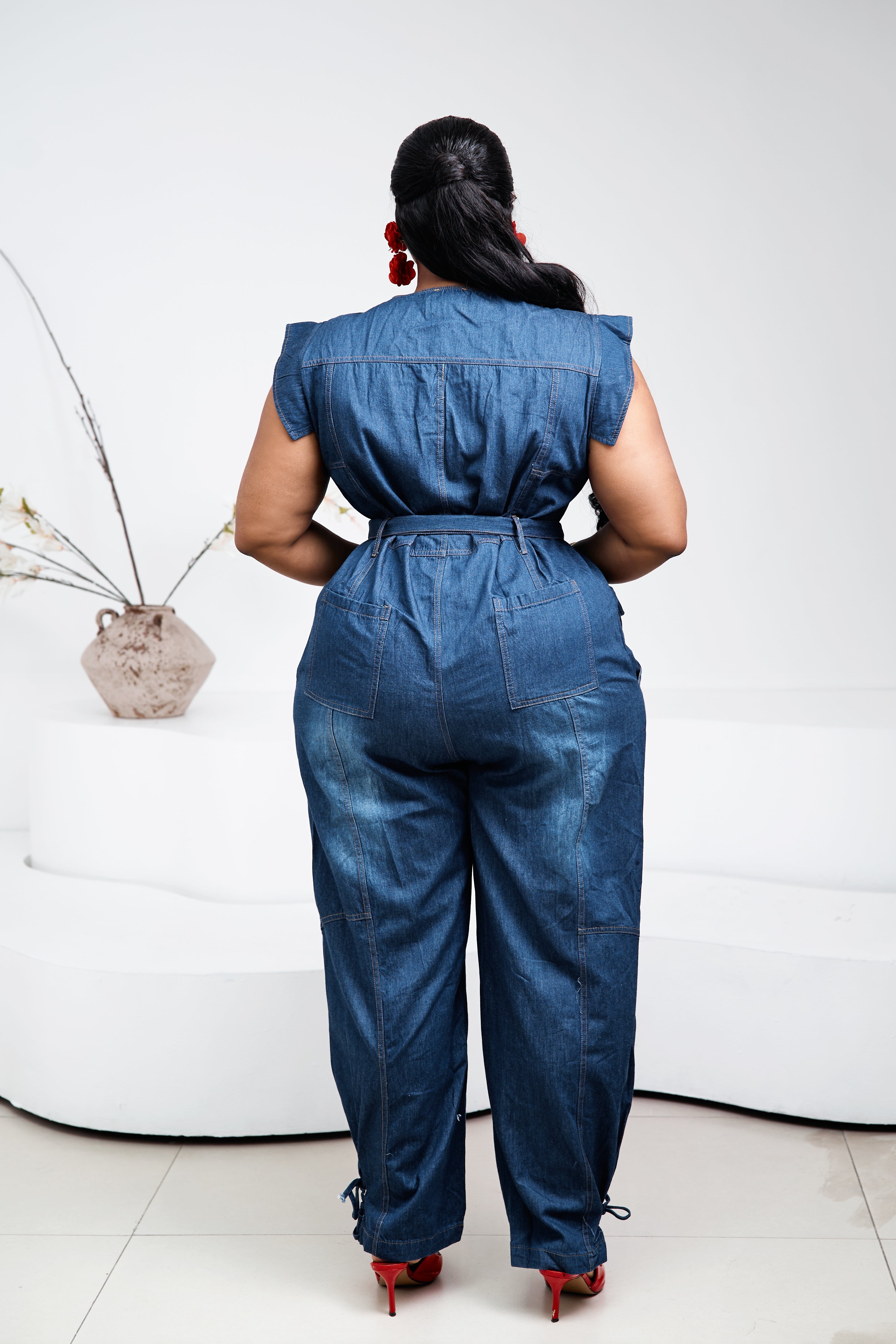 Sterra Fashion Stacia denim jumpsuit displayed on a hanger with front pockets and adjustable straps, casual and stylish for everyday wear.