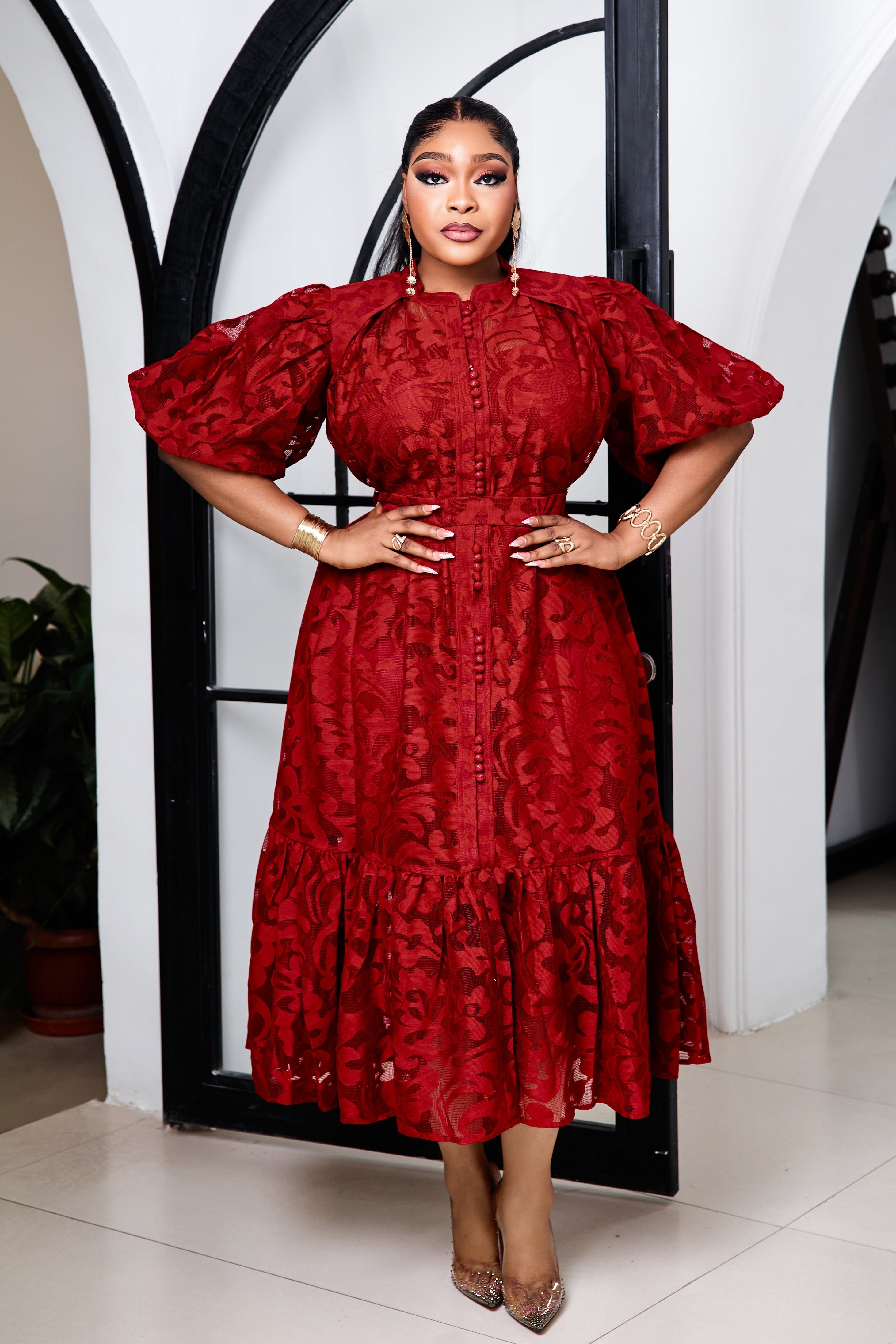 Sterra Fashion Duchess Rouge Lace Dress displayed on a hanger, showcasing elegant red lace fabric and detailed design.