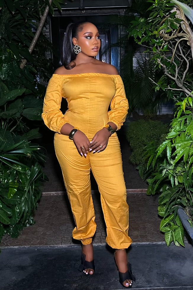 Saffron Aura STERA FASHION jumpsuit with a fitted waist and wide-leg pants, displayed on a model against a neutral background.