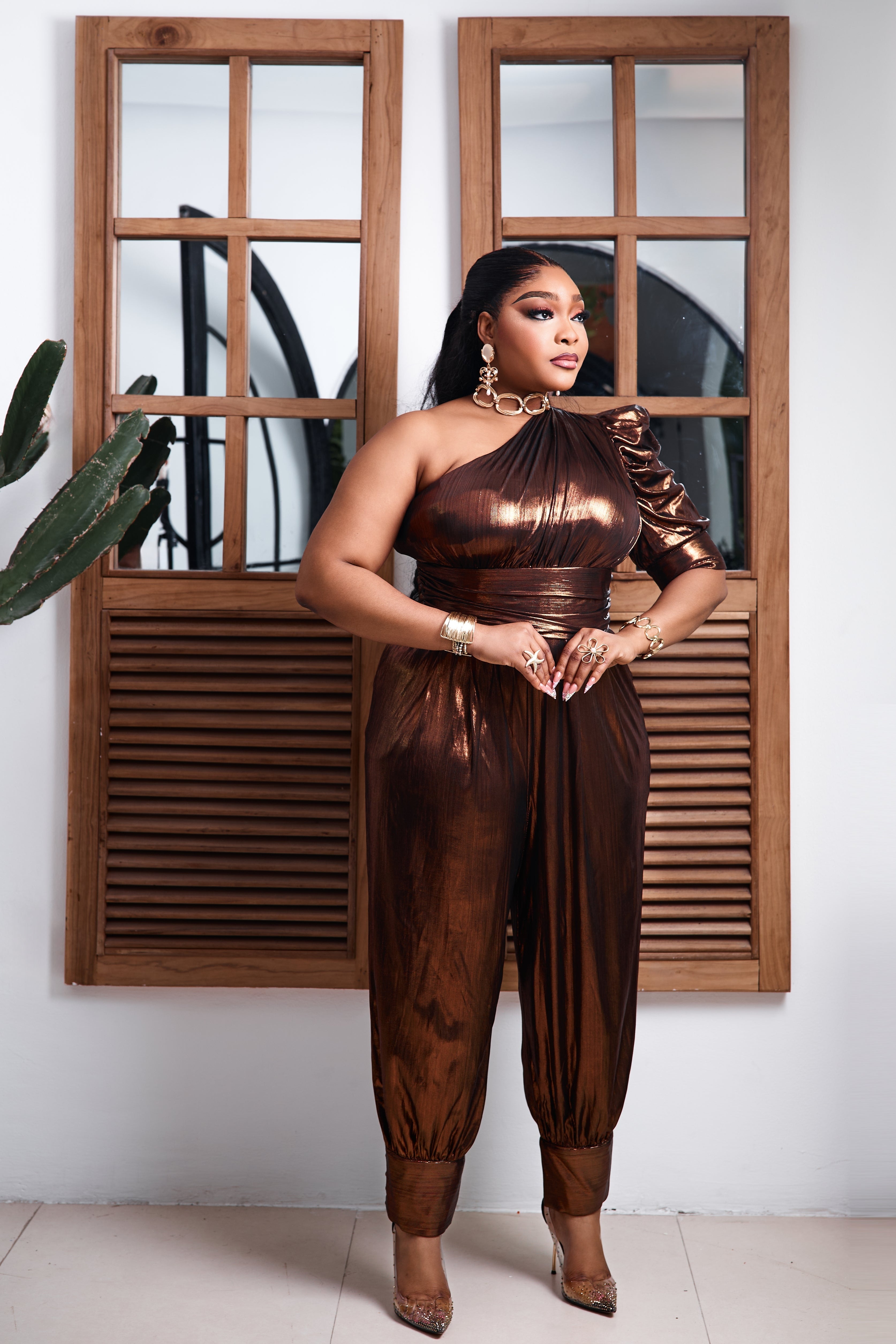 Bronze Goddess jumpsuit by STERA FASHION displayed on a hanger, featuring a flowing silhouette and elegant bronze color.