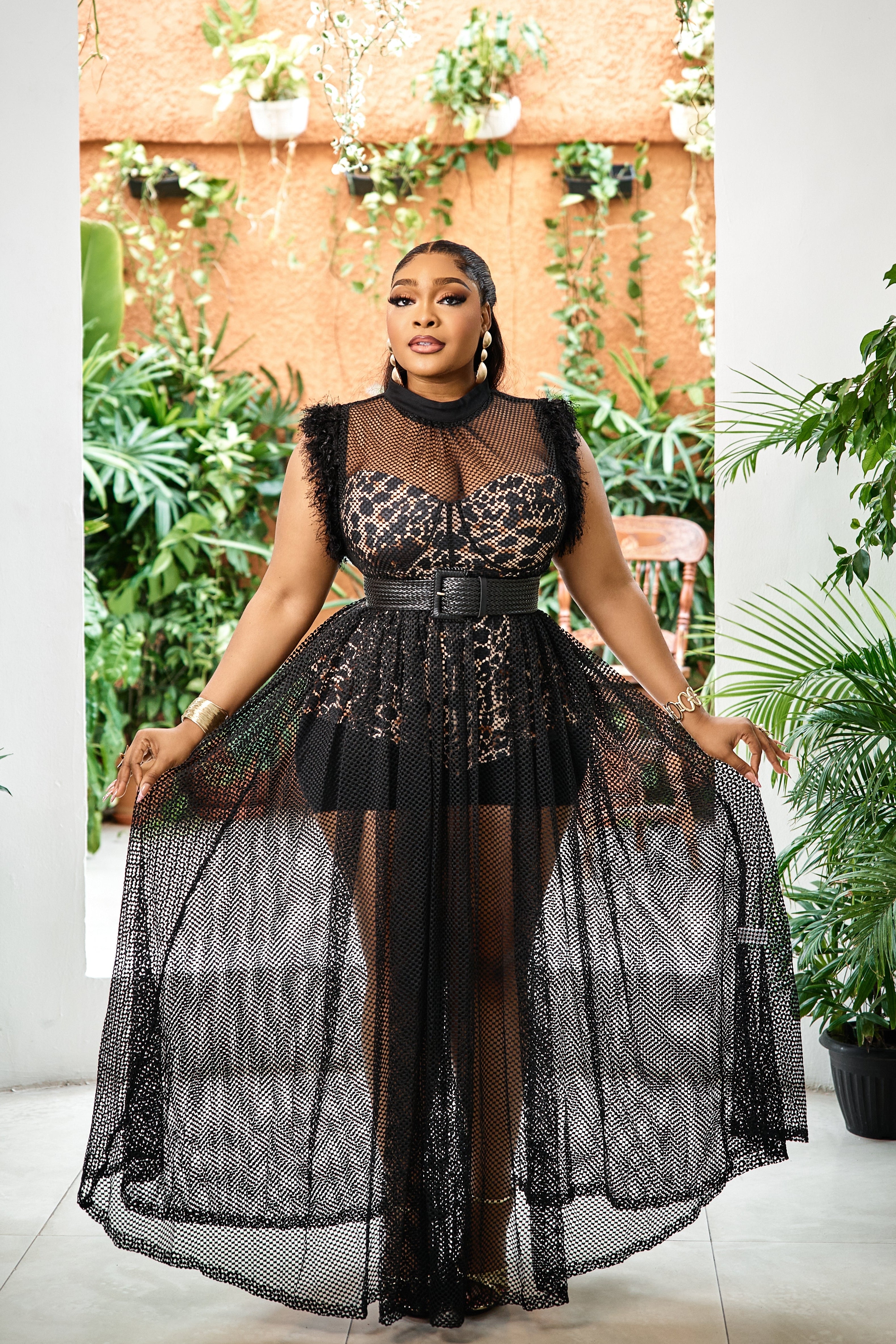 Elegant black Noir Éternelle Couture gown by STERA FASHION displayed on a hanger, showcasing intricate fabric details and sophisticated design.