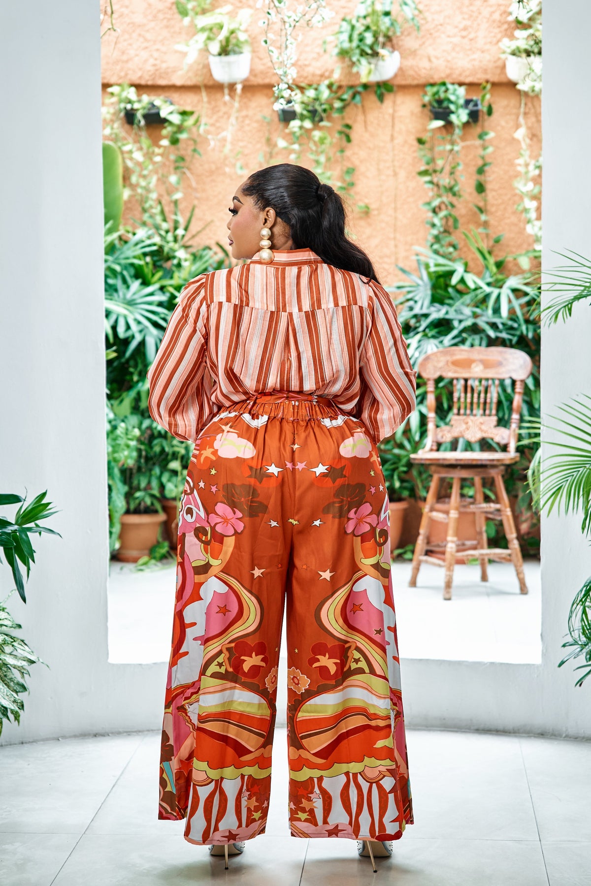 Sterra Fashion Portofino Sunset Palazzo Set displayed on a hanger with vibrant sunset-inspired fabric and flowing wide-leg pants.