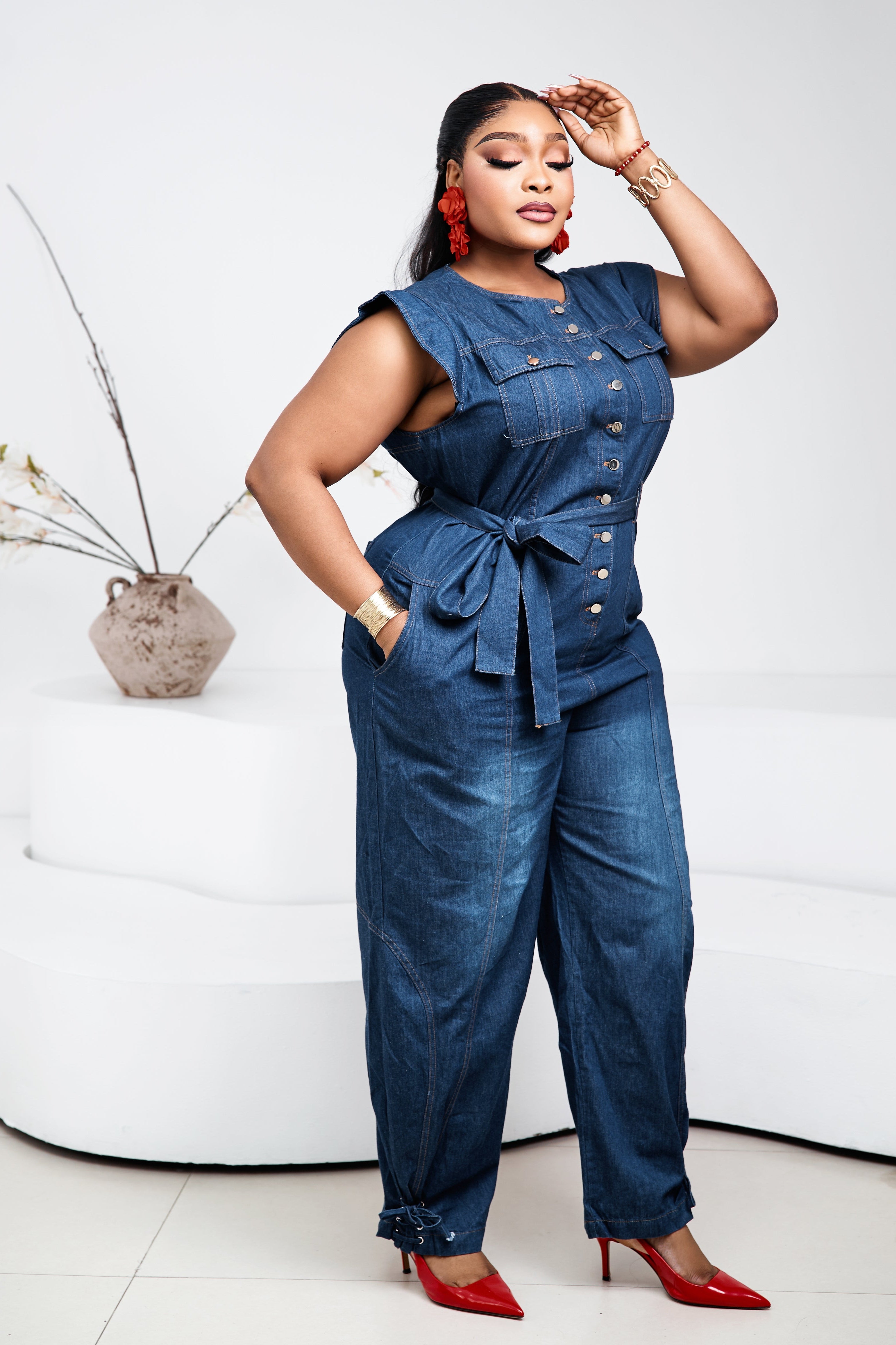 Sterra Fashion Stacia denim jumpsuit with adjustable straps and front pockets, shown on a model against a neutral background.