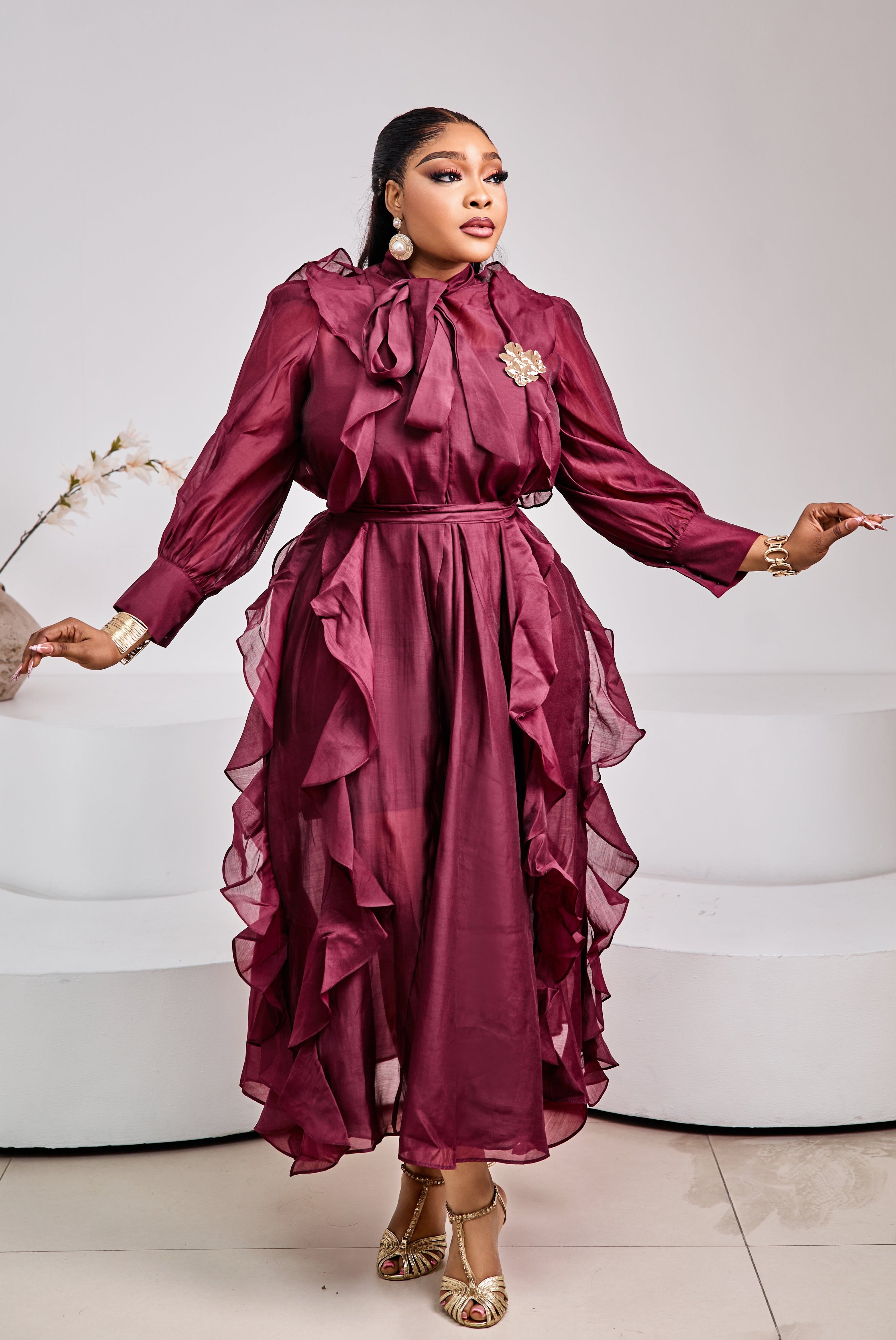Tuscan Bordeaux Ruffle Dress by STERA FASHION, featuring flowing fabric and ruffled details, displayed on a hanger against a neutral background.