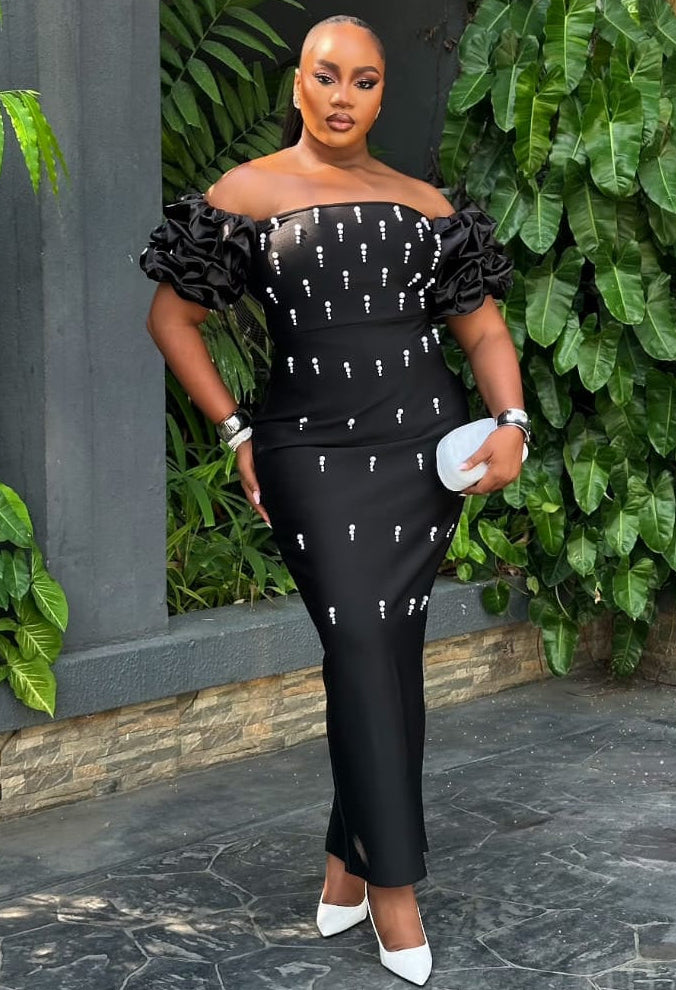 Elegant Noir Celeste gown by STERA FASHION displayed on a hanger with intricate details and flowing fabric.