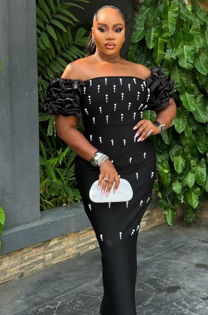 Elegant Noir Celeste gown by STERA FASHION featuring a flowing black fabric and intricate detailing for formal occasions.