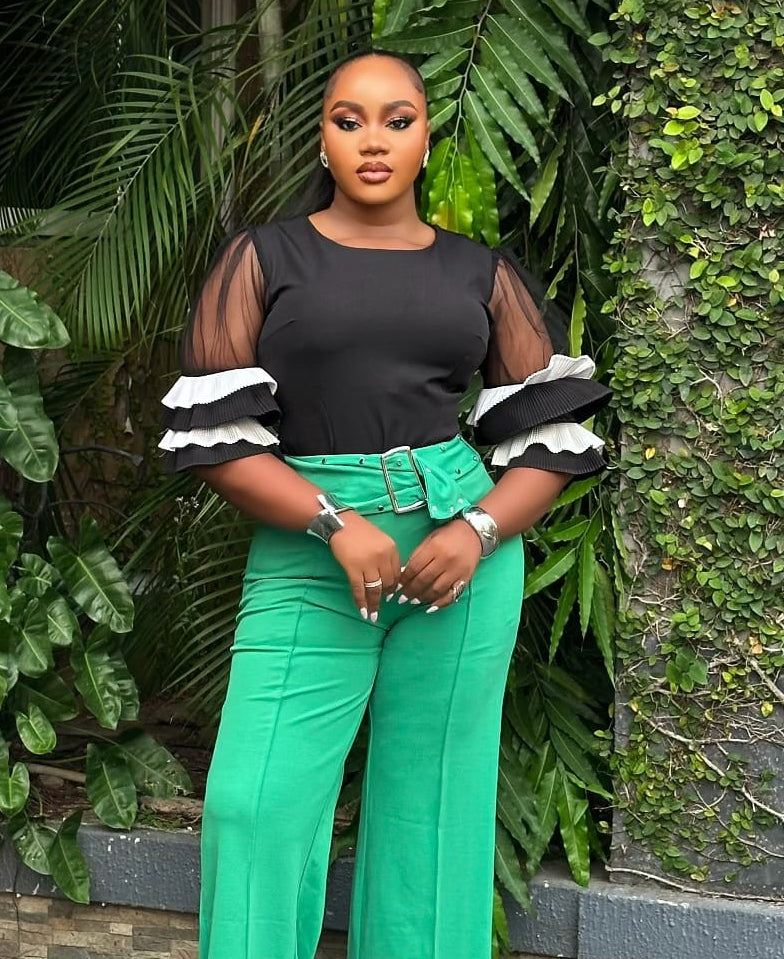 Emerald green STERA FASHION Poise pant with tailored fit and sleek design, displayed on a hanger.
